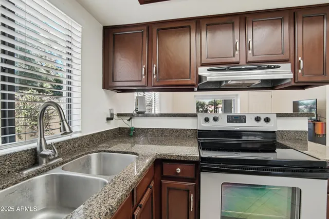 a kitchen with granite countertop a sink and a stove