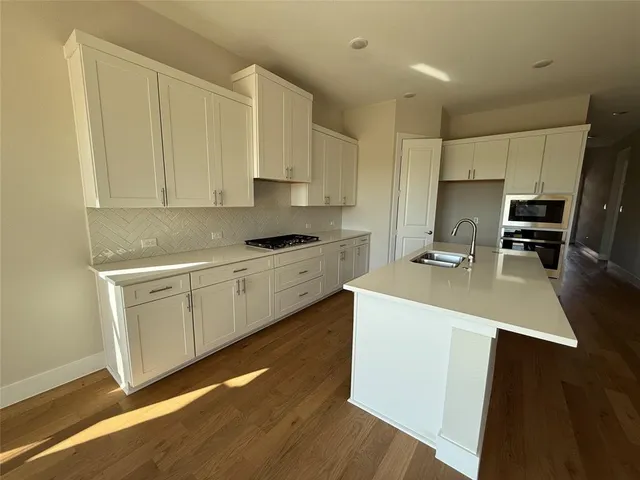 a kitchen with granite countertop a sink and a stove top oven