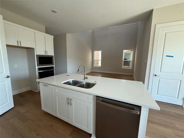 a kitchen with a sink a stove and cabinets