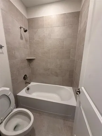 a white bath tub sitting next to a toilet