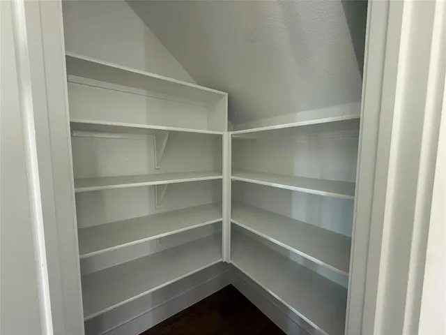 a view of walk in closet with empty racks
