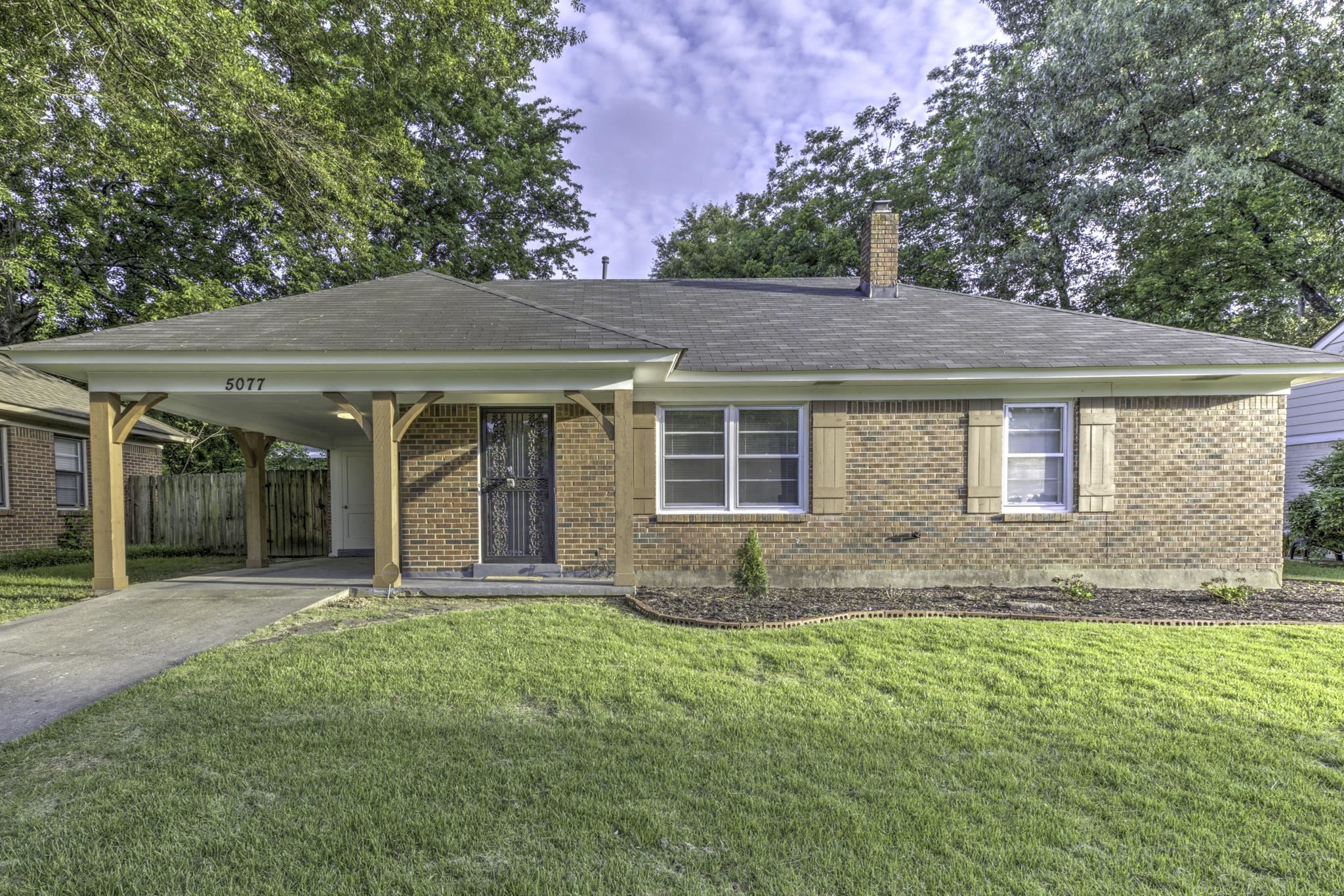 a front view of a house with a garden and yard