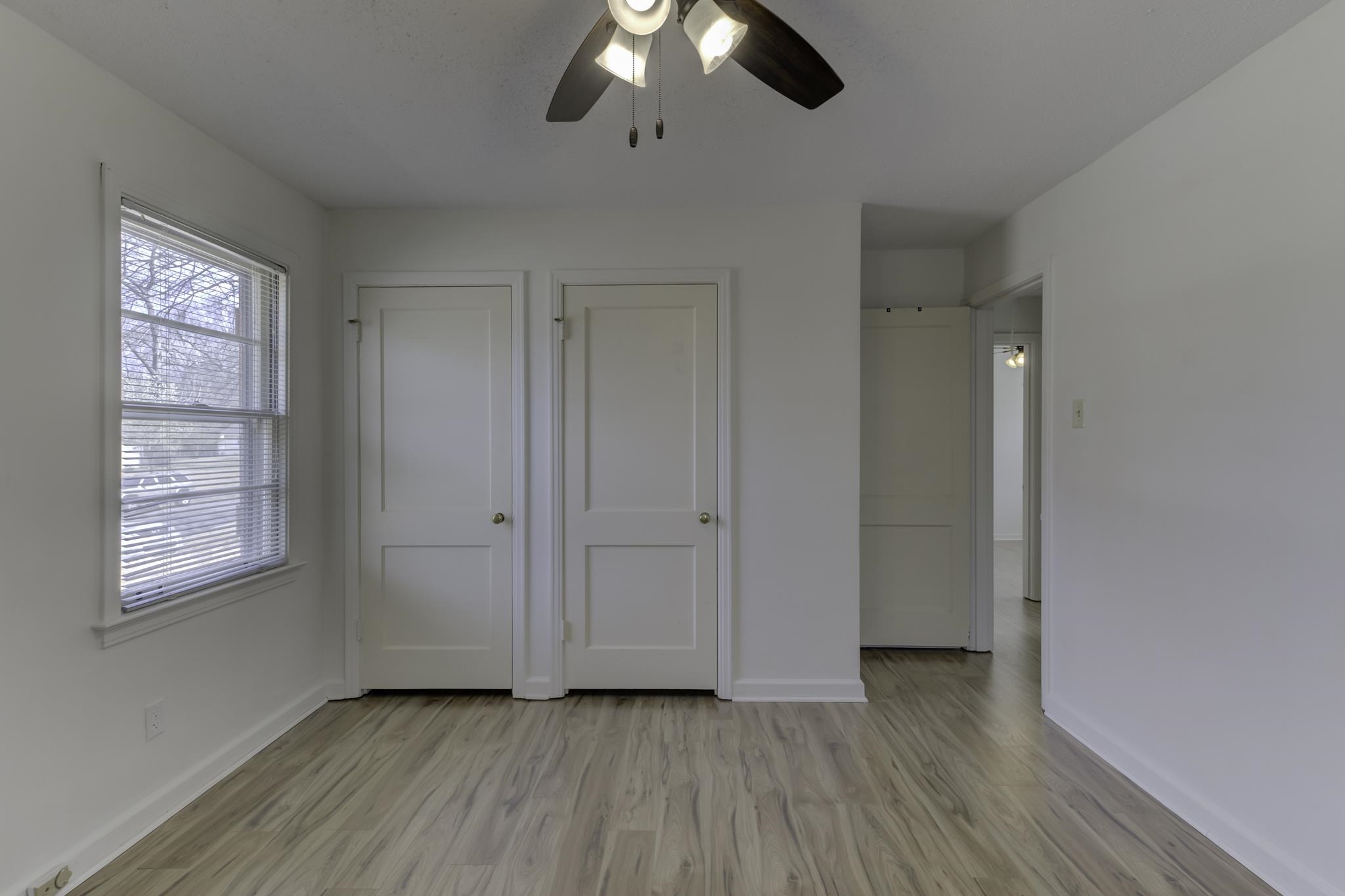 5077 New Castle Road Memphis, TN 38117 - Photo 27 of 37 a view of an empty room with wooden floor and window