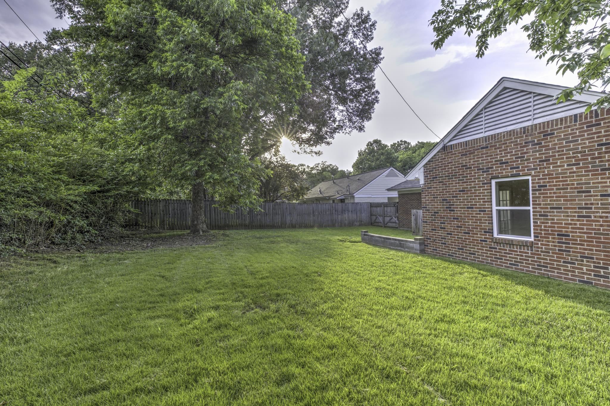 5077 New Castle Road Memphis, TN 38117 - Photo 34 of 37 a backyard of a house with lots of green space