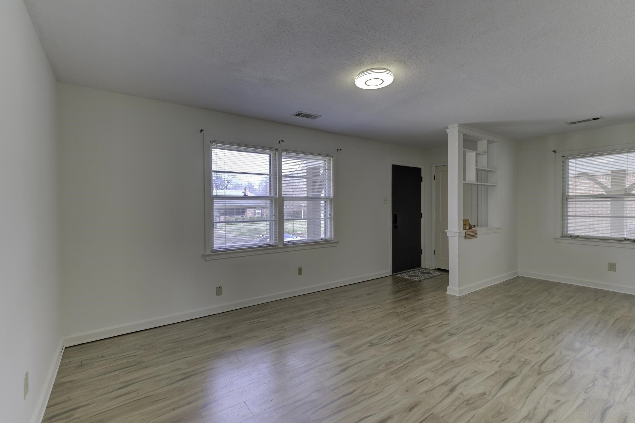 5077 New Castle Road Memphis, TN 38117 - Photo 7 of 37 an empty room with wooden floor and windows