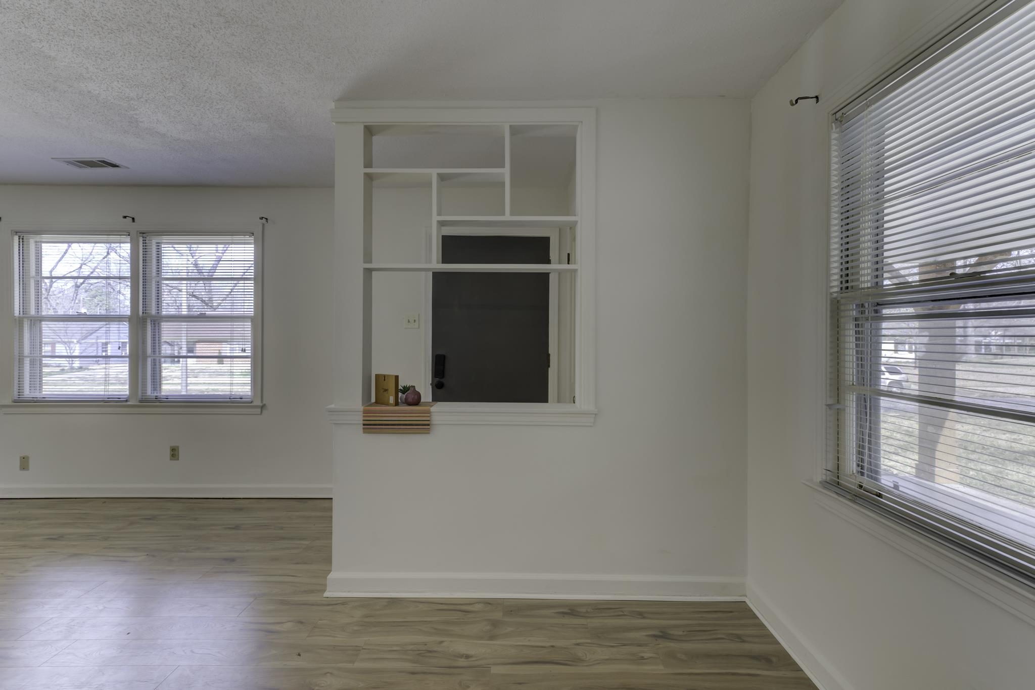 5077 New Castle Road Memphis, TN 38117 - Photo 9 of 37 an empty room with wooden floor and windows