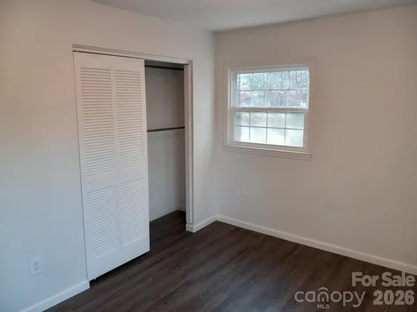 an empty room with wooden floor and a window