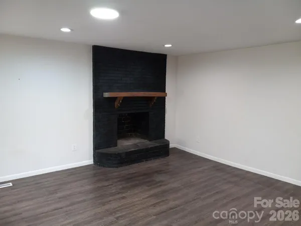 a room with wooden floor and a fireplace
