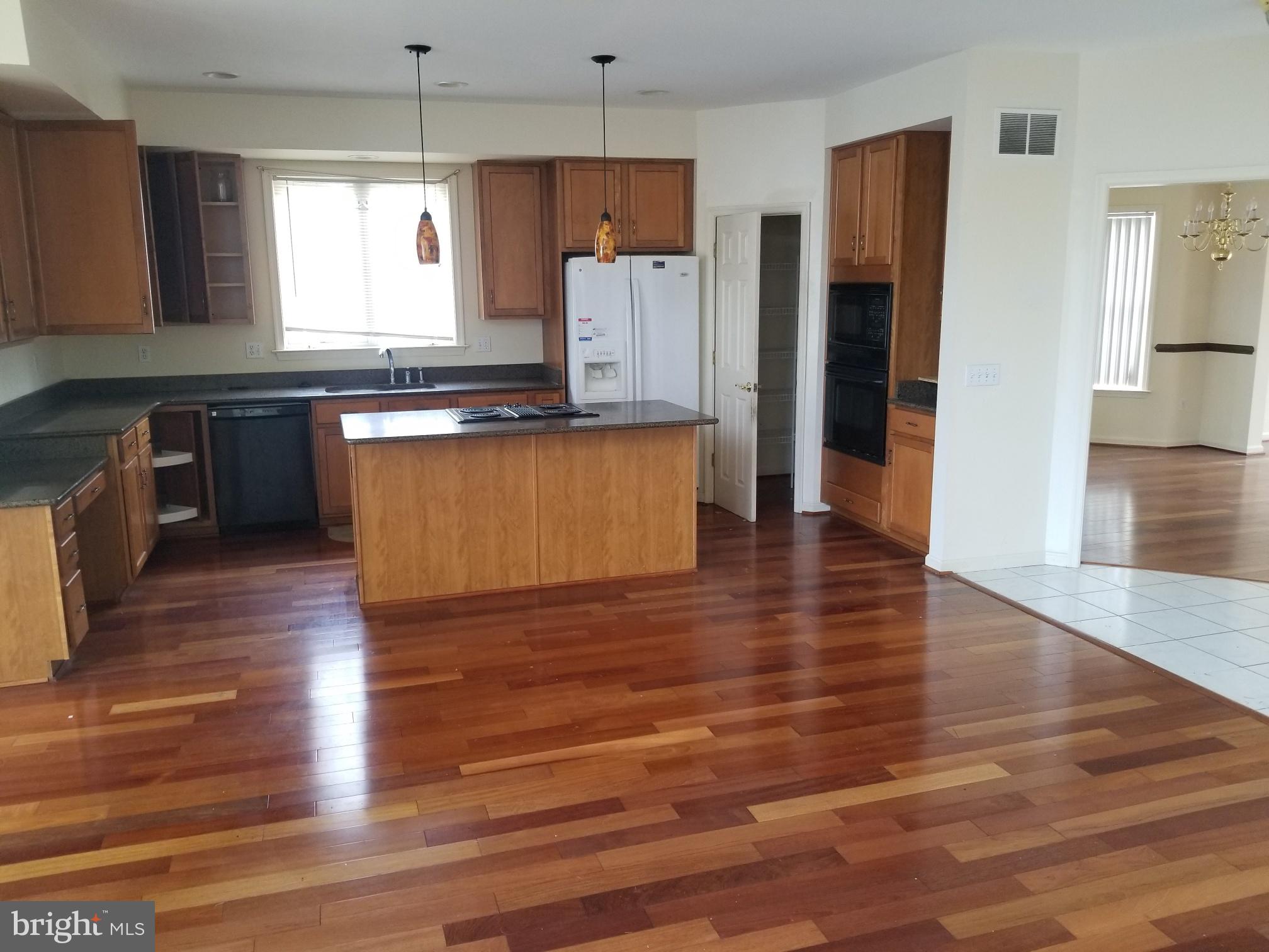 3943 Nelson House Road Ellicott City, MD 21043 - Photo 24 of 61 a kitchen with stainless steel appliances wooden floors and wooden cabinets