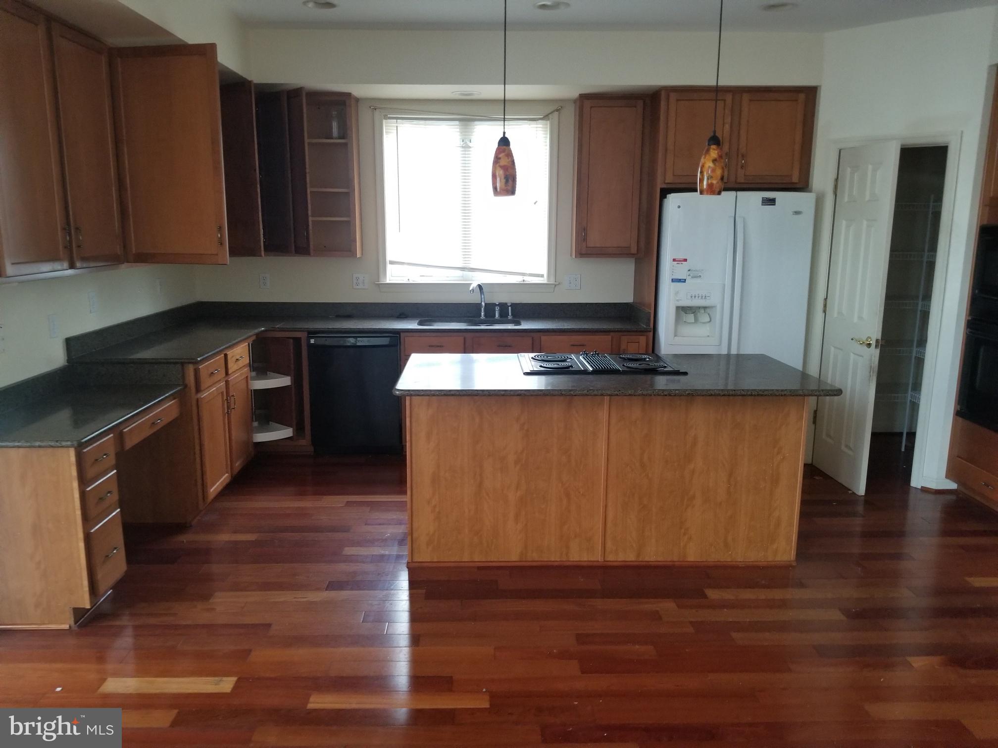 3943 Nelson House Road Ellicott City, MD 21043 - Photo 25 of 61 a kitchen with stainless steel appliances granite countertop a stove a refrigerator a sink and dishwasher with wooden floor