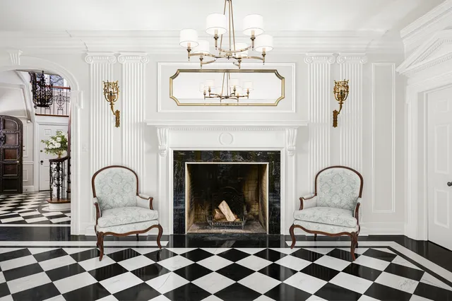 a living room with furniture a fireplace and a chandelier