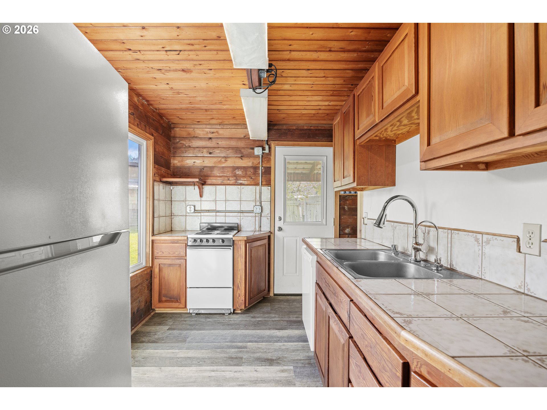 1250 North 3rd Avenue Powers, OR 97466 - Photo 19 of 48 a kitchen with a sink cabinets stainless steel appliances and a refrigerator