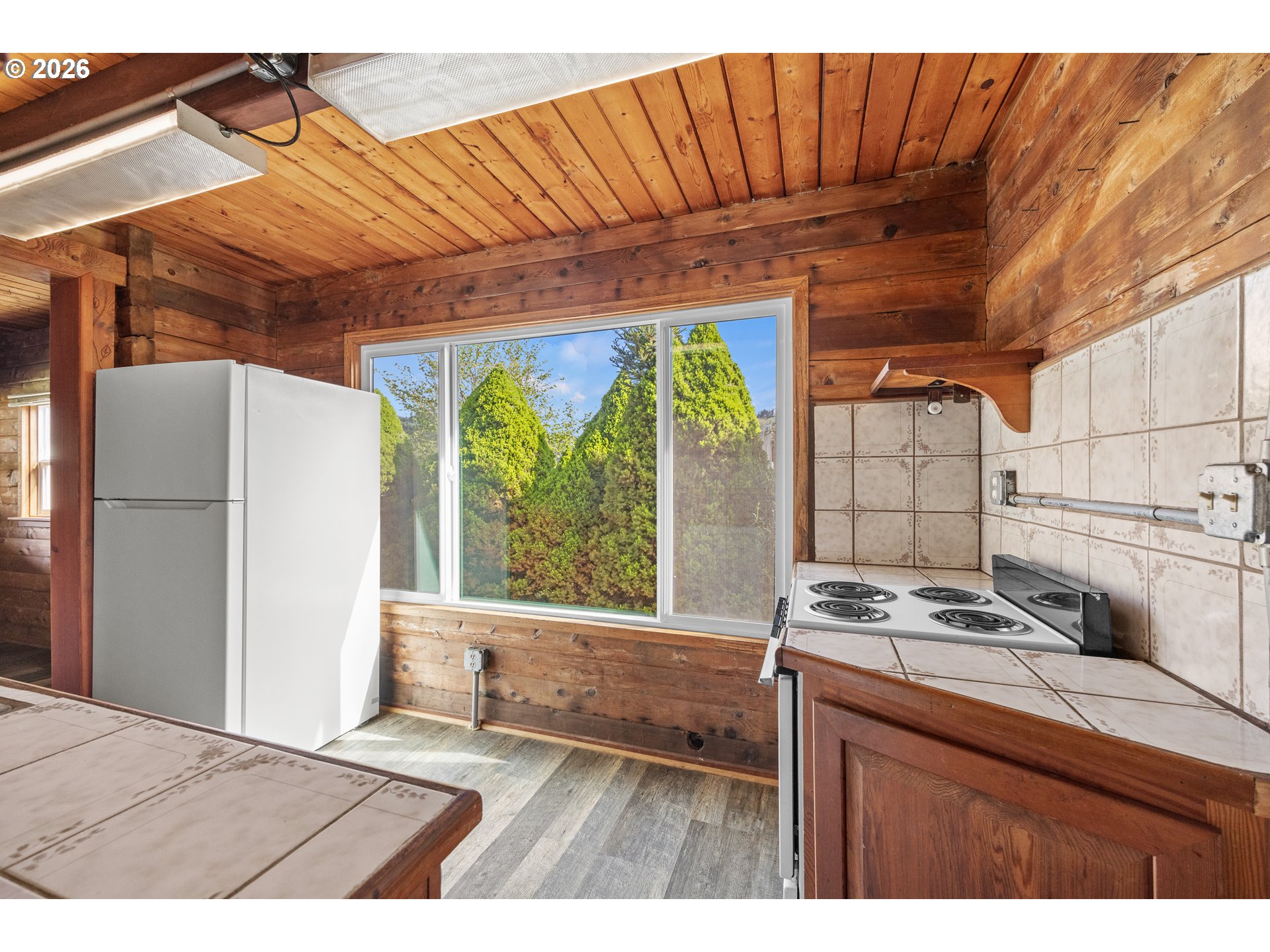 1250 North 3rd Avenue Powers, OR 97466 - Photo 20 of 48 a kitchen with a wooden floor and a window