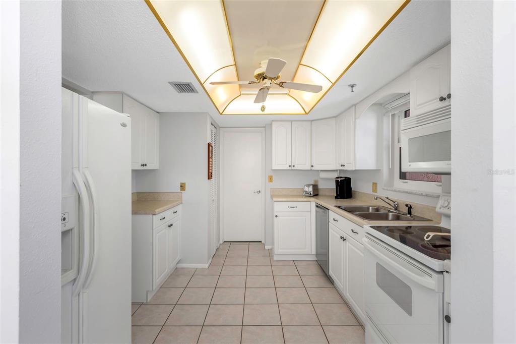 15316 Gulf Boulevard, Unit 604 Madeira Beach, FL 33708 - Photo 12 of 82 a kitchen with stainless steel appliances granite countertop a refrigerator and a sink