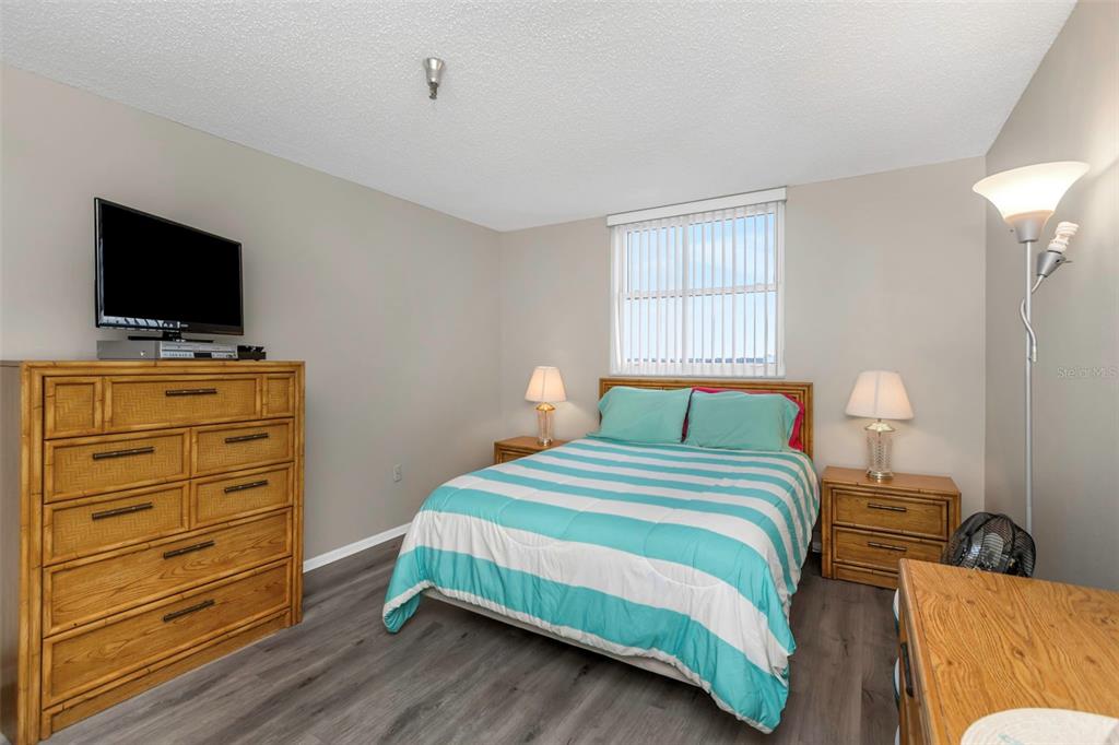 15316 Gulf Boulevard, Unit 604 Madeira Beach, FL 33708 - Photo 35 of 82 a bedroom with a bed and a flat screen tv