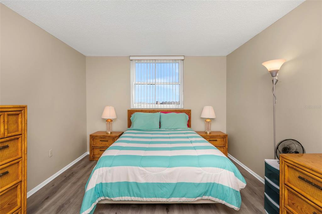 15316 Gulf Boulevard, Unit 604 Madeira Beach, FL 33708 - Photo 36 of 82 a bedroom with bed and wooden floor