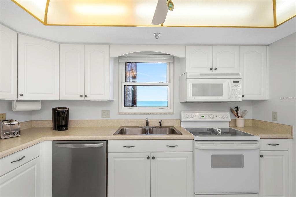 15316 Gulf Boulevard, Unit 604 Madeira Beach, FL 33708 - Photo 9 of 82 a kitchen with cabinets appliances a sink and a counter top space