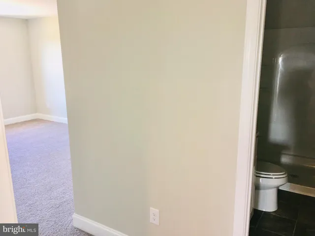 an empty room with wooden floor fireplace and windows