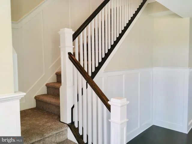 a view of staircase with white walls and a window