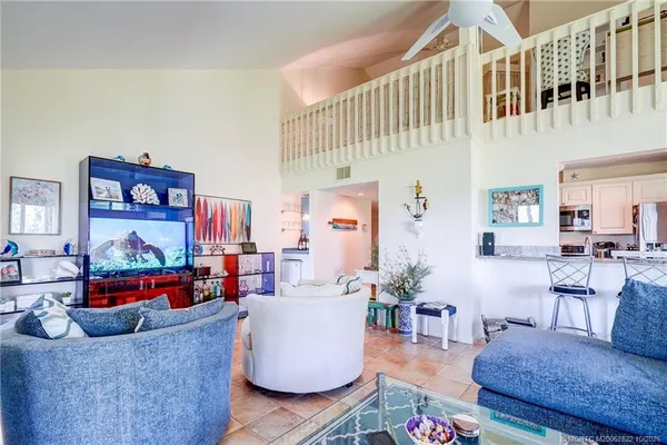 a view of a dining room and livingroom with furniture a chandelier and wooden floor