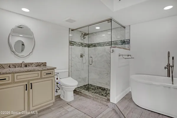 a bathroom with a granite countertop toilet sink and mirror