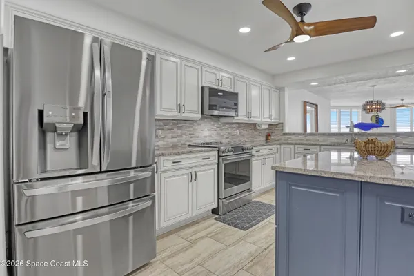 a kitchen with granite countertop a refrigerator stove and sink