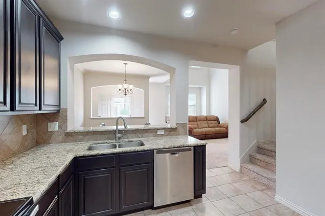 a kitchen with stainless steel appliances granite countertop a refrigerator and a sink