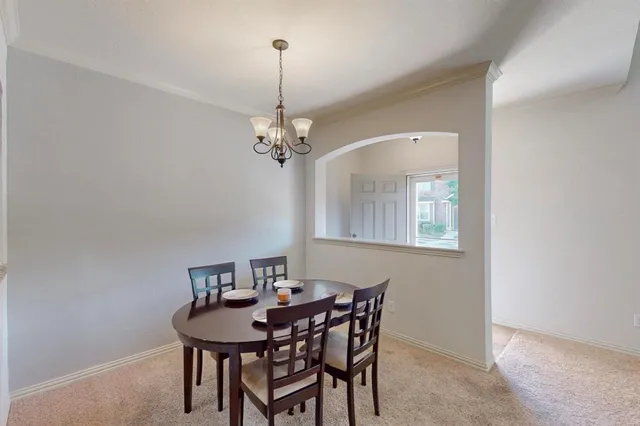 a view of a dining room with furniture and chandelier