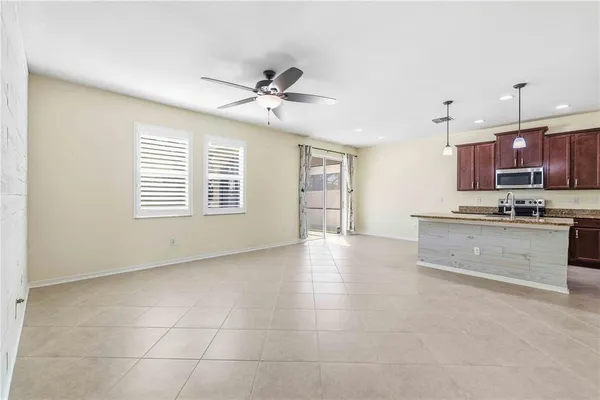a view of kitchen with stainless steel appliances granite countertop a stove a sink a refrigerator a microwave oven with white cabinets