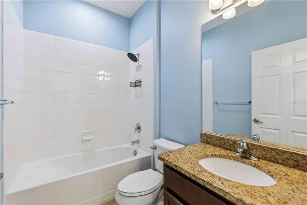 a bathroom with a granite countertop sink toilet mirror and shower