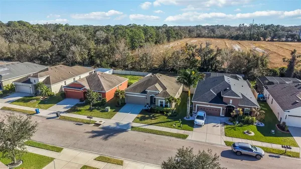 an aerial view of a house with a garden and lake view