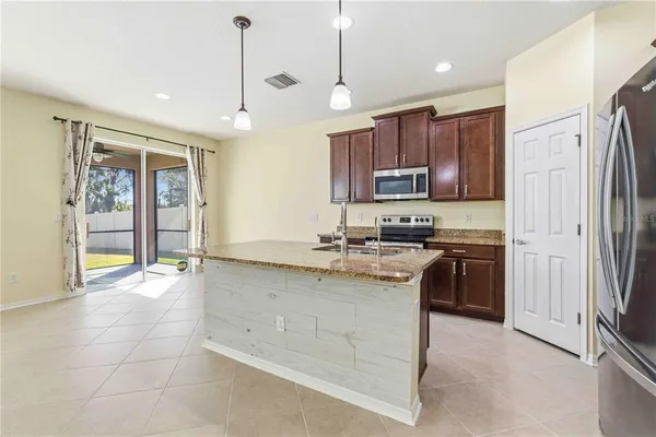 a kitchen with stainless steel appliances granite countertop a refrigerator a sink and a stove
