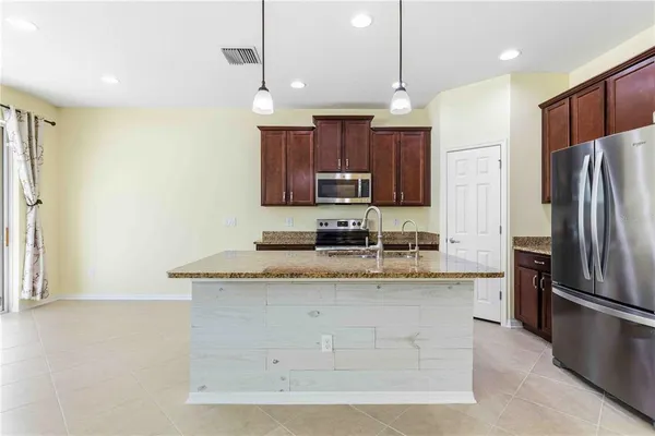 a kitchen with stainless steel appliances granite countertop a sink a refrigerator and a stove
