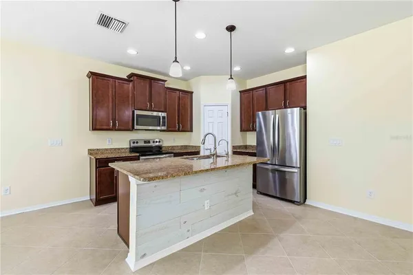 a kitchen with stainless steel appliances granite countertop a refrigerator a stove a sink and a refrigerator
