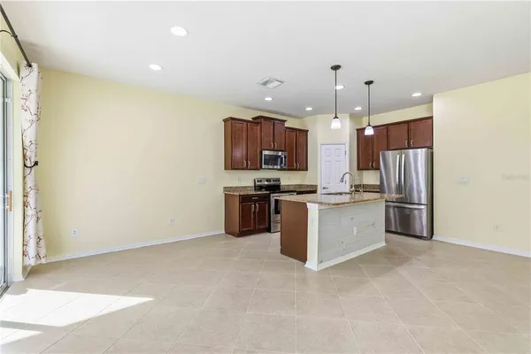 a kitchen with stainless steel appliances granite countertop a refrigerator sink and stove