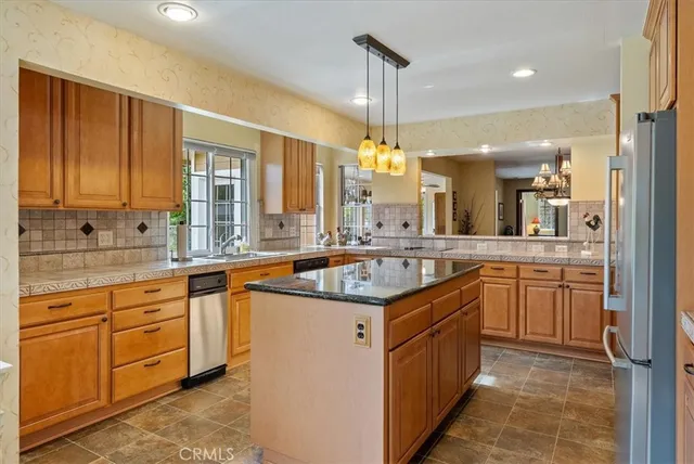 a kitchen with stainless steel appliances granite countertop a sink and a large window