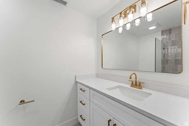 1898 West 600 South Provo, UT 84601 - Photo 13 of 32 White vanity with panel cabinetry and brass hardware, featuring an integrated sink and light-toned countertop