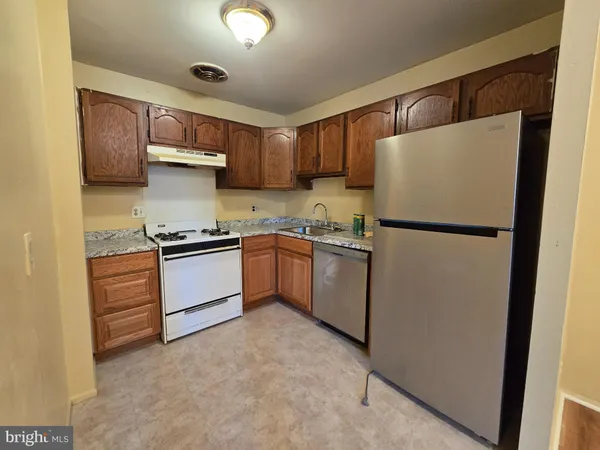 a kitchen with a refrigerator sink and cabinets