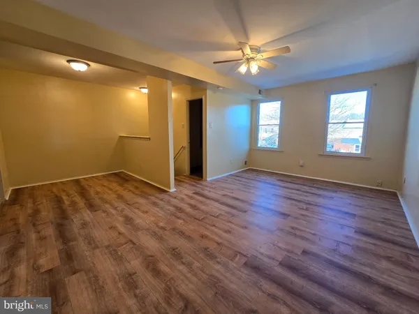 a view of empty room with window and ceiling fan