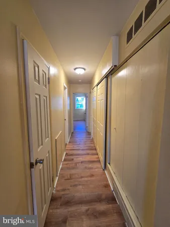 a view of a hallway with wooden floor and stairs