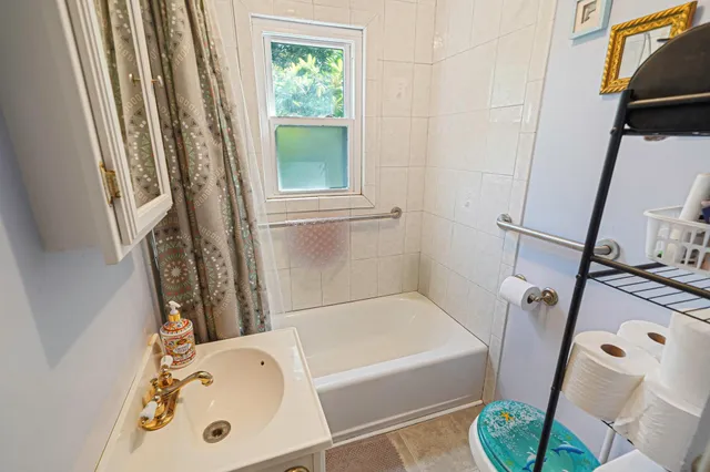 a bathroom with a tub a window and a sink