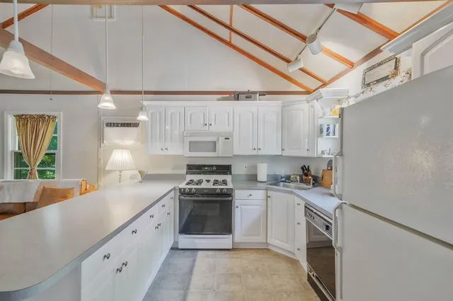 a kitchen with stainless steel appliances granite countertop a sink a stove and cabinets