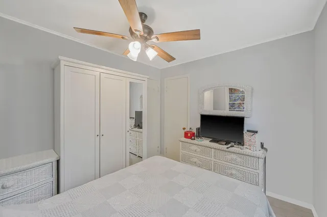 a bedroom with a bed and a flat tv screen on a dresser