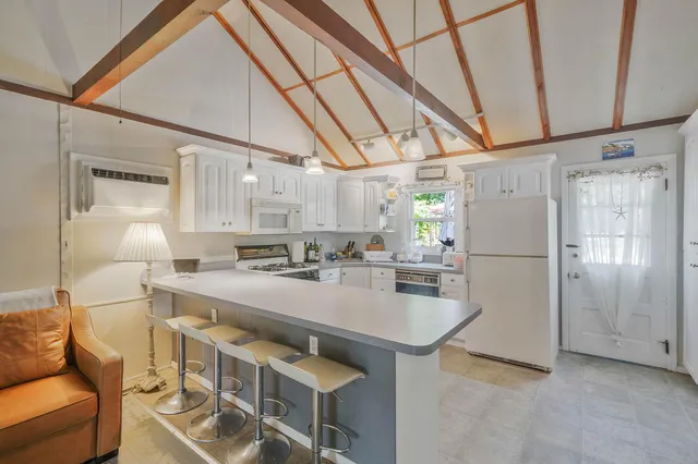 a kitchen with kitchen island a stove a refrigerator and a couch