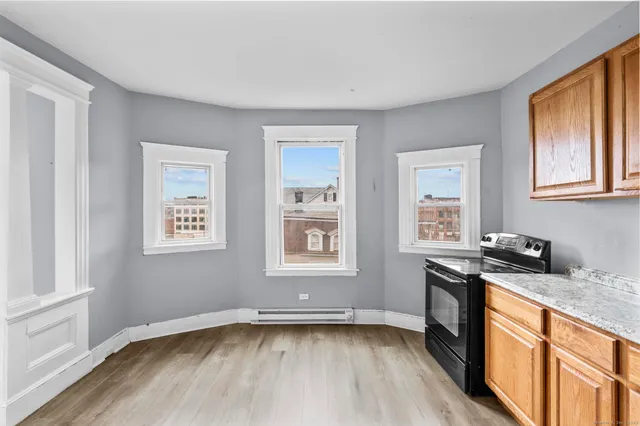 a view of a kitchen with wooden floor and electronic appliances
