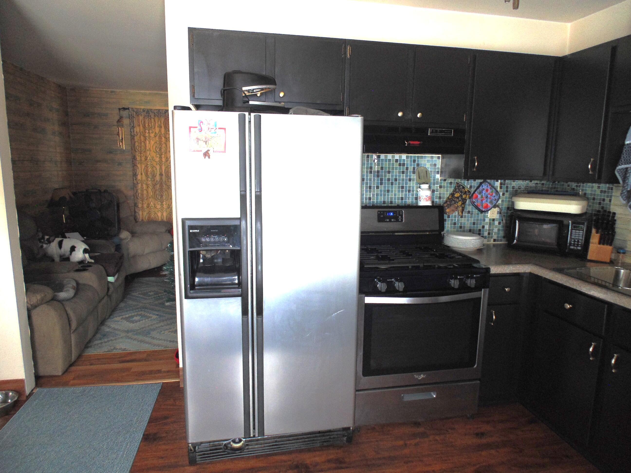 3170 Lawrence Street Hobart, IN 46342 - Photo 4 of 11 a kitchen with stainless steel appliances kitchen island granite countertop a refrigerator and a stove
