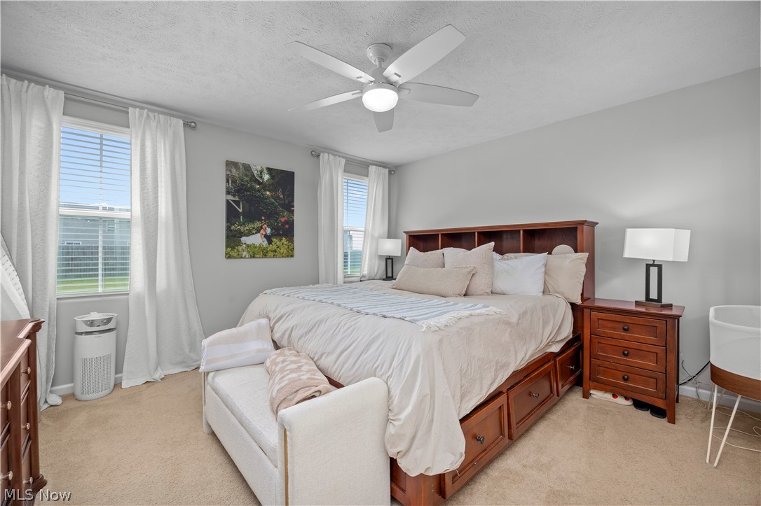 2161 Fowl Road Elyria, OH 44035 - Photo 16 of 46 Bedroom featuring a ceiling fan with integrated lighting, two windows with blinds and drapes, and neutral carpet flooring