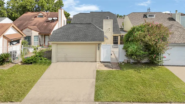 front view of house with a yard and trees