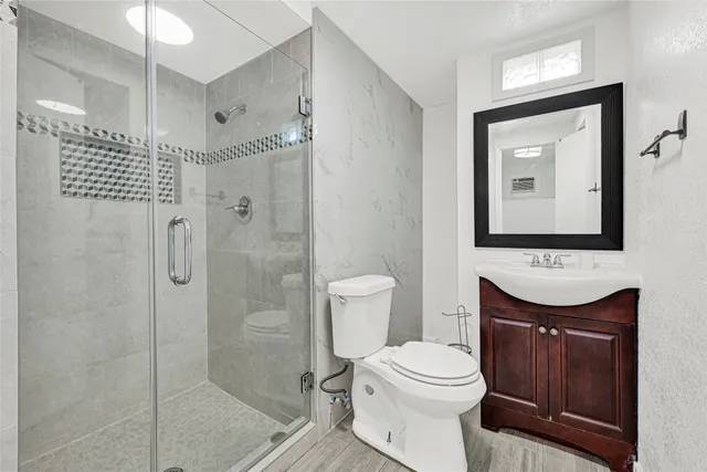 a bathroom with a toilet a sink and shower