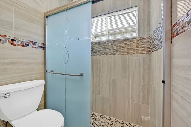 a bathroom with a toilet and a shower